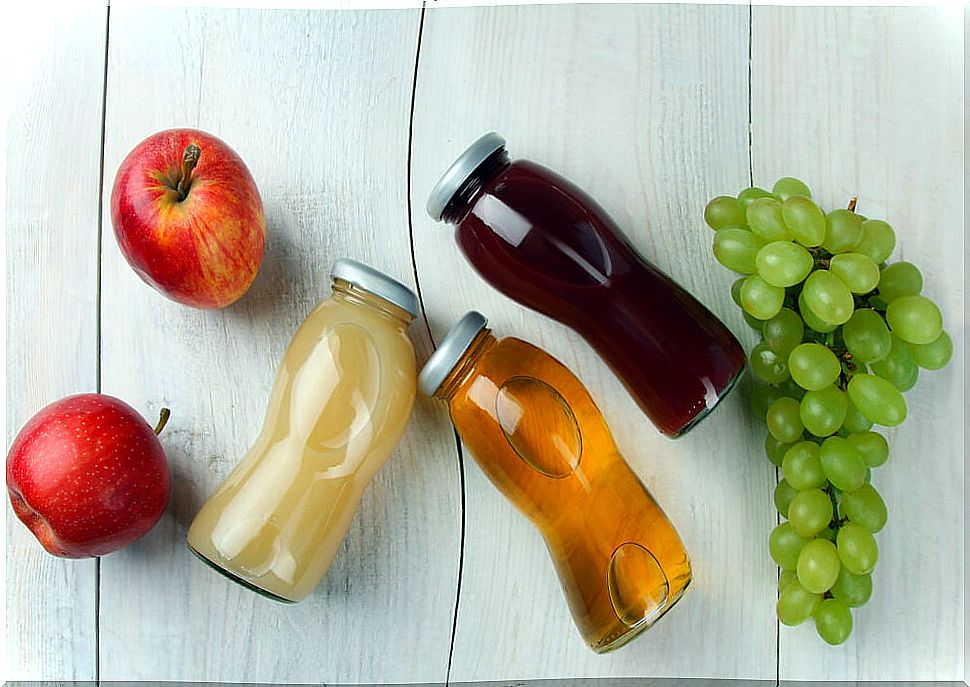 Jars with drinks, apples and a bunch of grapes