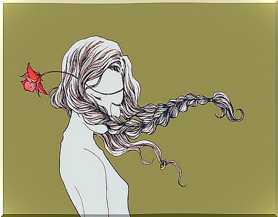 Woman with hair in the wind and a flower 