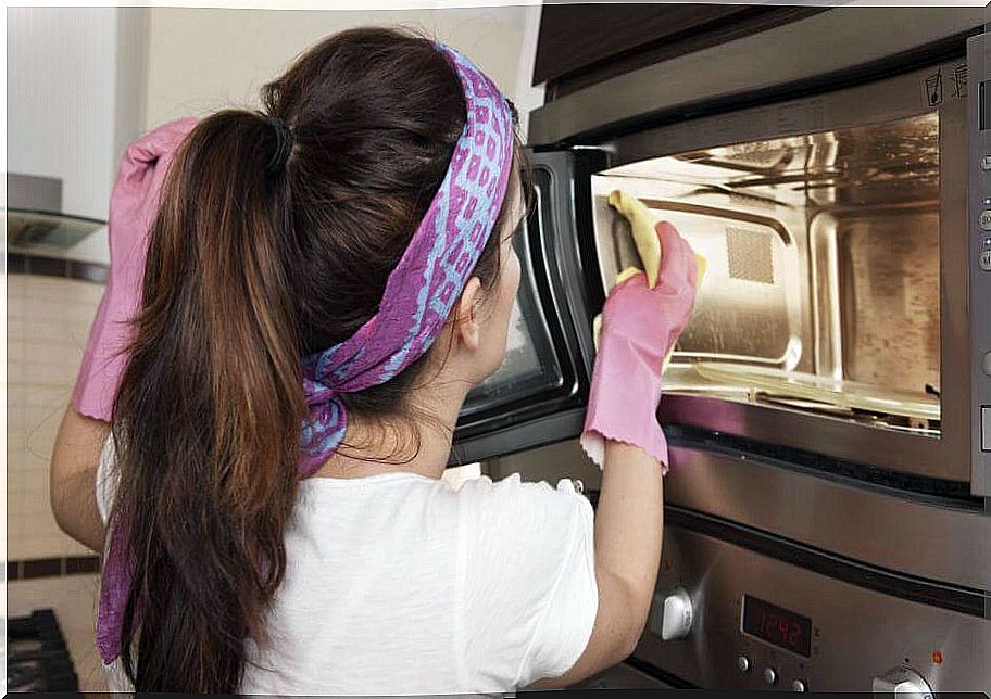 Woman cleaning the microwave