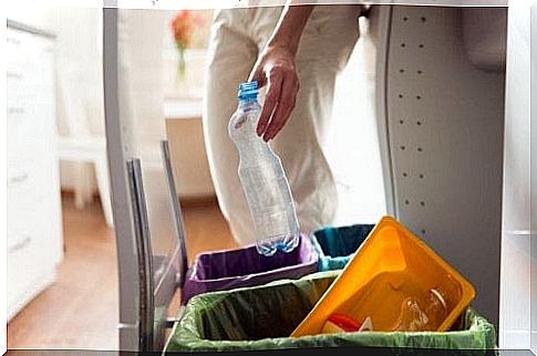 Woman recycling a plastic bottle: reducing waste