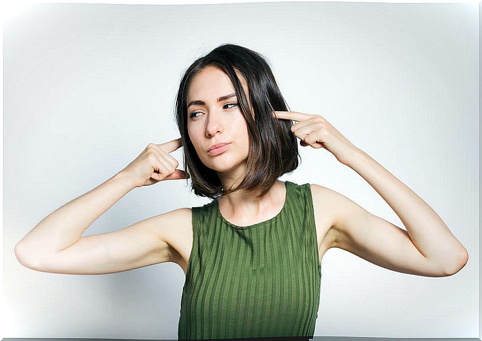 Woman covering her ears from noise.