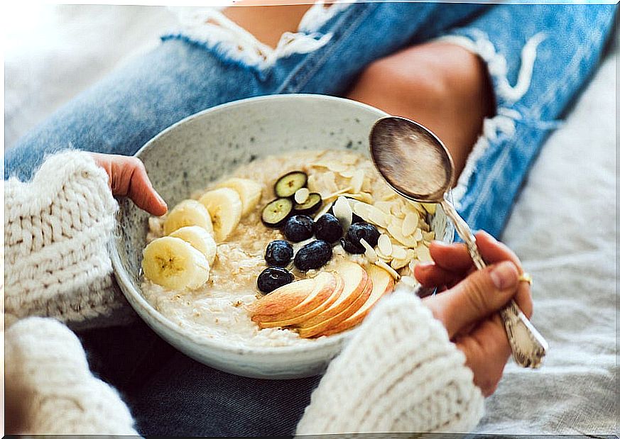 Woman with plate of bircher muesli in winter.